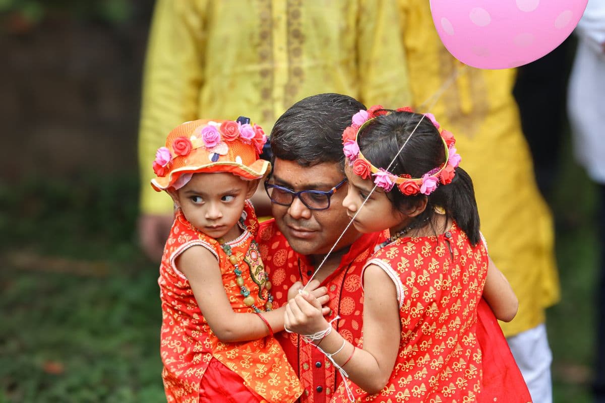 A father spending time with his daughters in Dhaka; illustrative stock photo, not an ASOK Foundation event